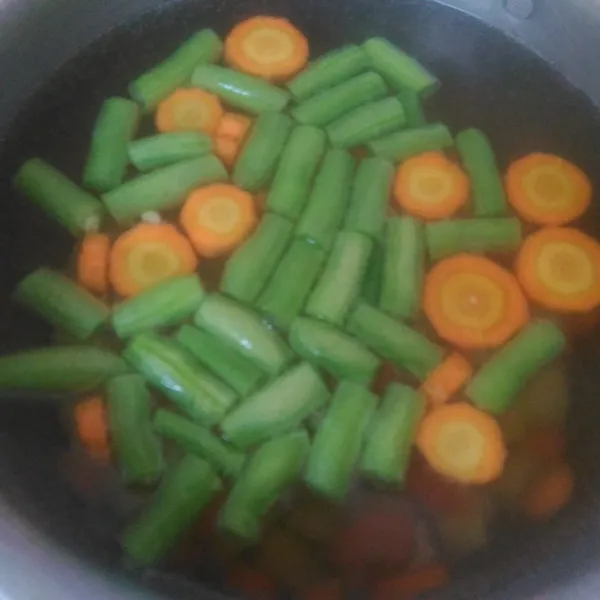 Didihkan air, setelah mendidih masukkan kentang, wortel, dan buncis. Rebus hingga setengah matang.