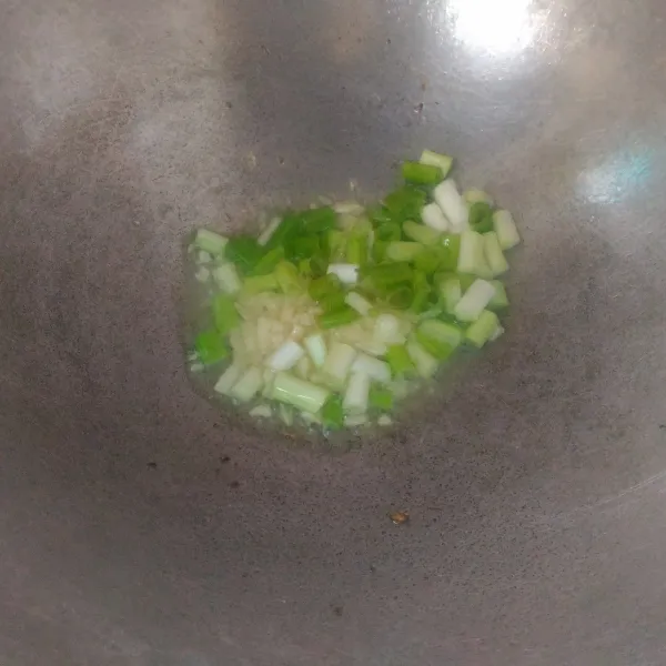 Tumis bawang putih dan daun bawang hingga harum dan matang.