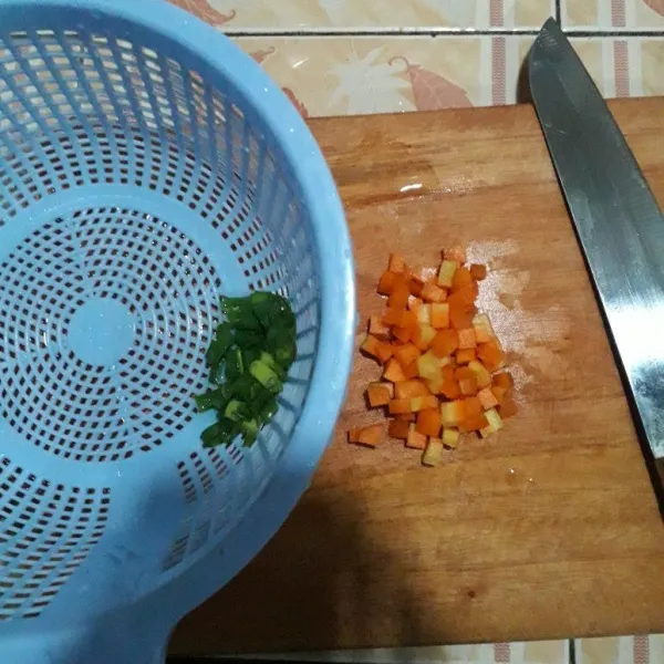 Potong wortel menjadi kotak-kotak. Lalu iris daun bawang lalu cuci keduanya.
