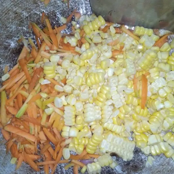 Masukkan jagung dan wortel, aduk rata. Masak sampai setengah matang.