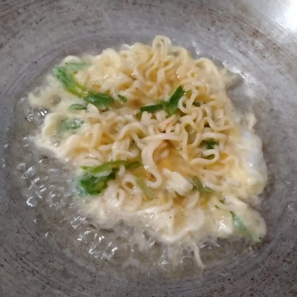 Panaskan minyak goreng dalam wajan. Kemudian tuang adonan ke dalam minyak panas.