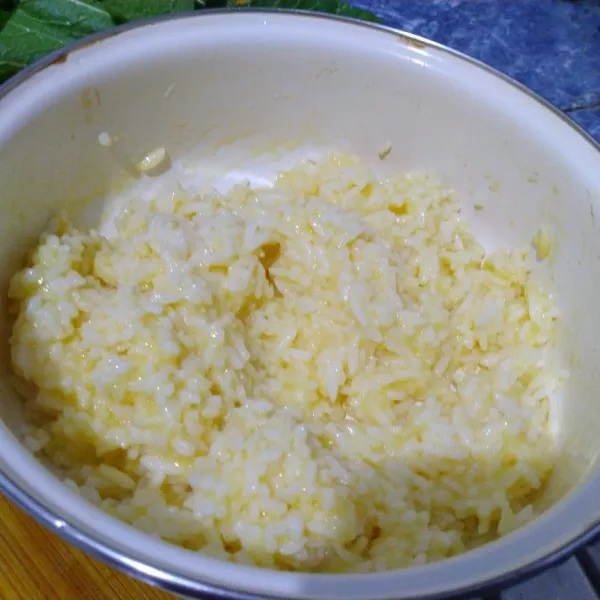 Taruh nasi ke dalam mangkuk. Pecahkan telur dan campur rata dengan nasi. Sisihkan.