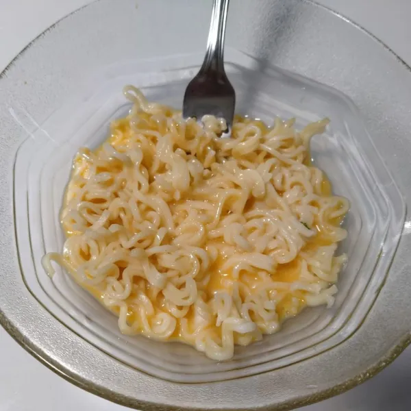 Masukkan mie instan rebus. Aduk.