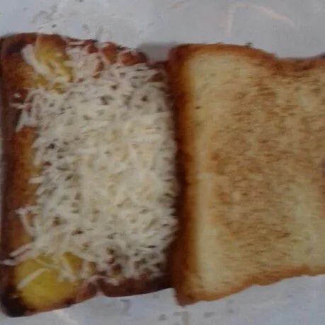 Ambil 2 lembar lagi, beri 1 sisi roti dengan keju cheddar parut, tangkupkan roti lainnya.