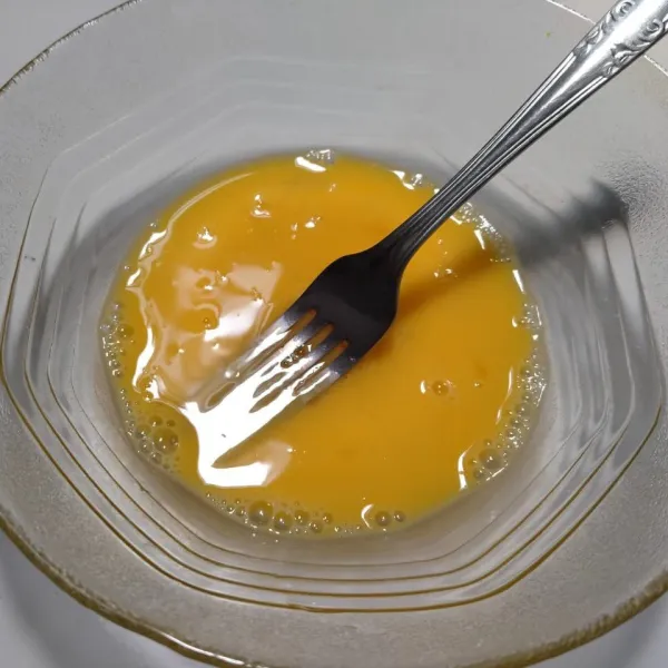 Pecah telur ke dalam mangkuk, kemudian kocok lepas.