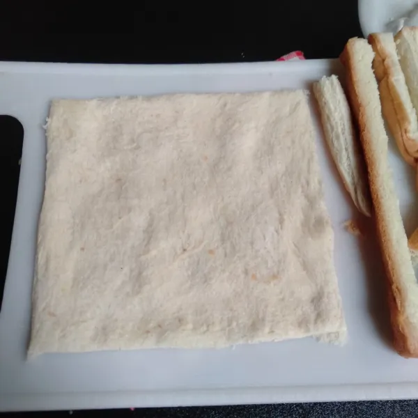 Pipihkan roti supaya mudah digulung (potong sisinya klo rotinya bukan tawar kupas).