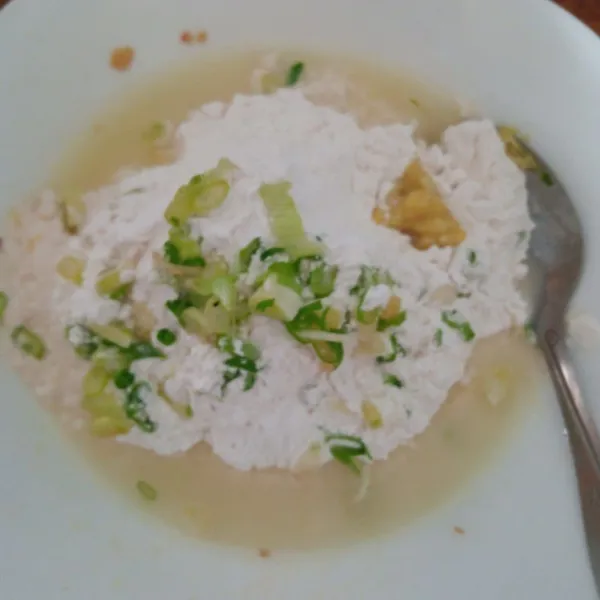 Campurkan tapioka, daun bawang dan bumbu halus sambil tuangin air hangat sedikit sedikit sampai kalis.