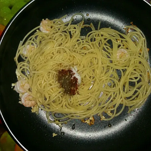 Masukkan spaghetti, bumbui garam, lada hitam/putih, chili flakes/bon cabe dan oregano kering jika ada. Aduk-aduk hingga bumbu merata