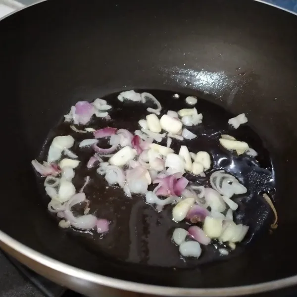Iris bawang merah dan bawang putih, lalu tumis hingga layu dan harum