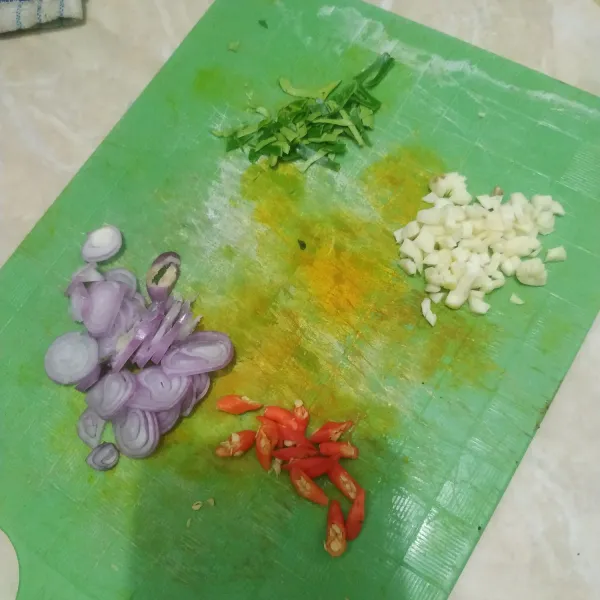 Siapkan bumbu. Iris tipis bawang merah dan cabe rawit. Cincang halus bawang putih. Rajang halus daun jeruk.