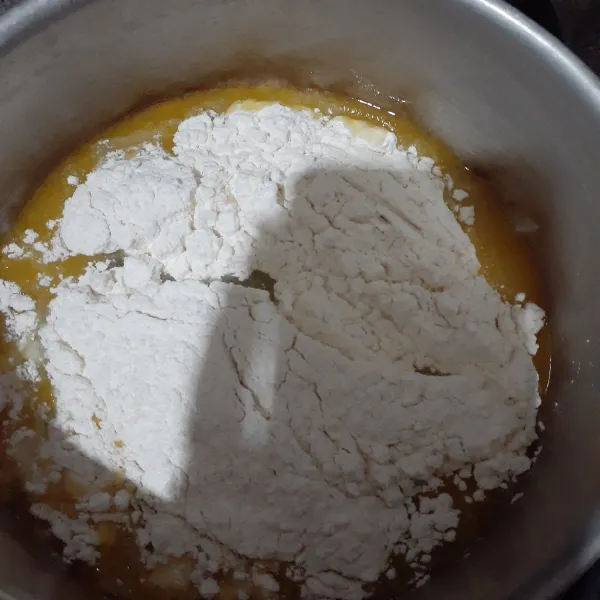 Setelah tercampur, masukkan tepung terigu. Aduk cepat hingga adonan menjadi kalis