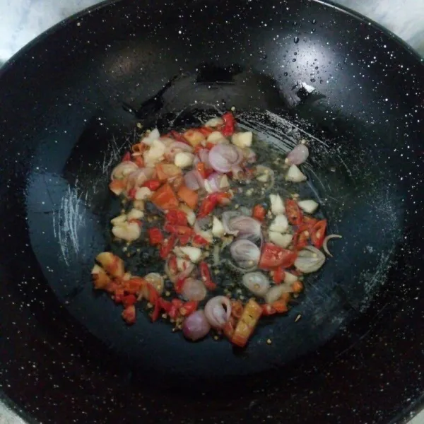 Panaskan minyak, masukkan bawang merah, bawang putih, cabai keriting, cabai rawit dan tomat. Tumis hingga matang dan harum