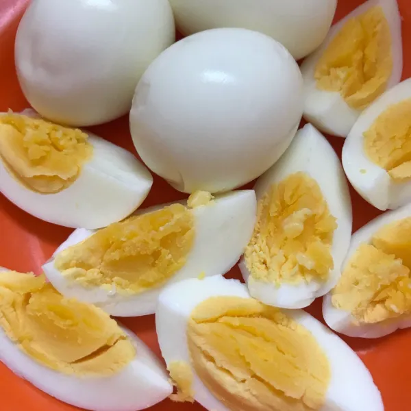 Rebus telur hingga matang, lalu dibelah menjadi beberapa bagian.