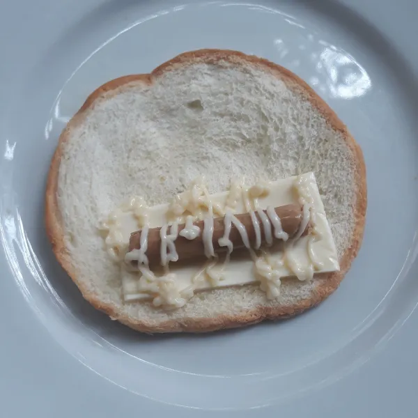 Letakkan keju slices, sosis sonice,mayones,lalu gulung dan beri perekat ujungnya dengan kuning telur