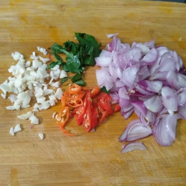 Iris bawang merah, daun kesum, dan cabe rawit. Cincang halus bawang putih
