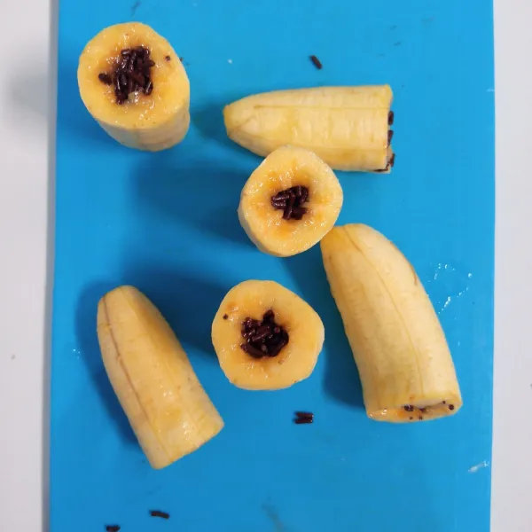 Lubangi pisang dengan sedotan. Kemudian isi mesis/coklat blok di dalamnya