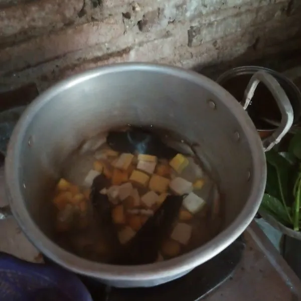 Setelah mendidih, masukkan tahu dan wortel, tutup sampai matang.