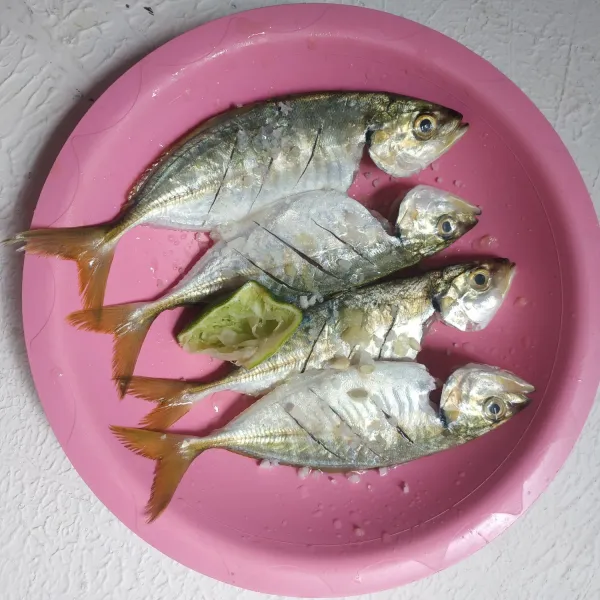 Siangi ikan, buang kotorannya,beri garam dan perasan jeruk nipis, marinasi 10 menit, kemudian cuci bersih