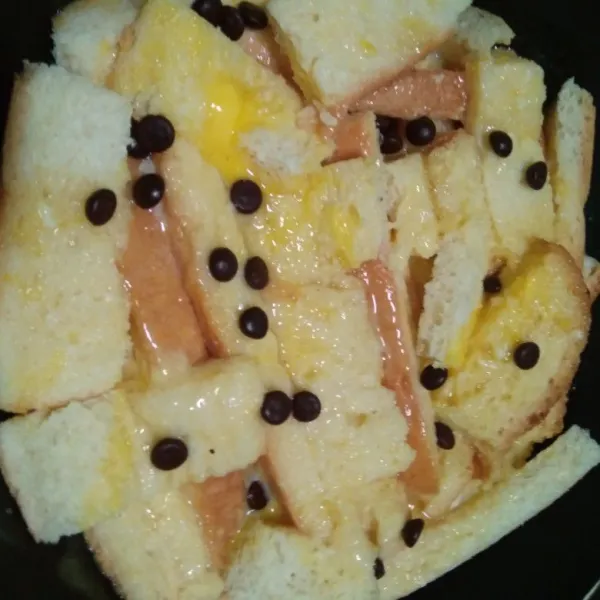 Tuang campuran susu kedalam potongan roti sampai rata, taburi chocochips