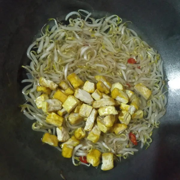 Tambahkan tahu, bumbui garam, gula, merica bubuk dan kaldu bubuk, koreksi rasanya, masak sampai tauge matang