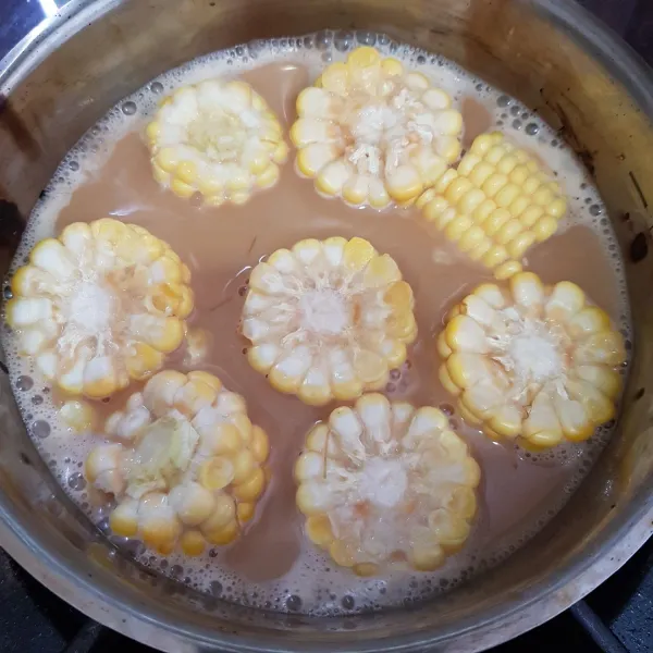 Setelah campuran creamer dan gula palm mendidih, masukkan potongan jagung manis. Aduk rata dan masak hingga air menyusut.
