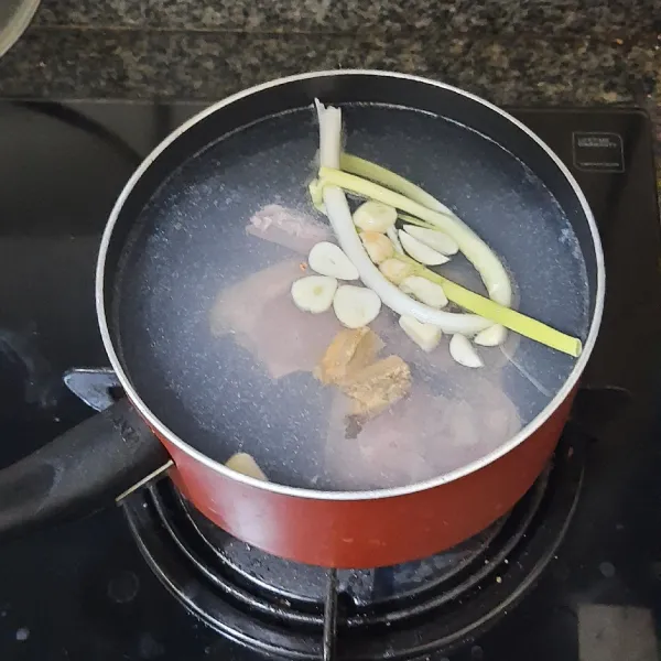 Tuang air ke dalam panci, masukkan ayam, bawang putih, daun bawang dan jahe. Masak hingga ayam matang