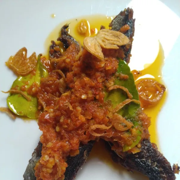 Tuang bumbu di atas ikan goreng. Sajikan