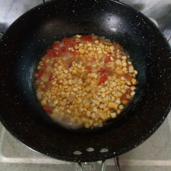 Kemudian masukkan jagung dan tuangi air. Masak hingga jagung empuk