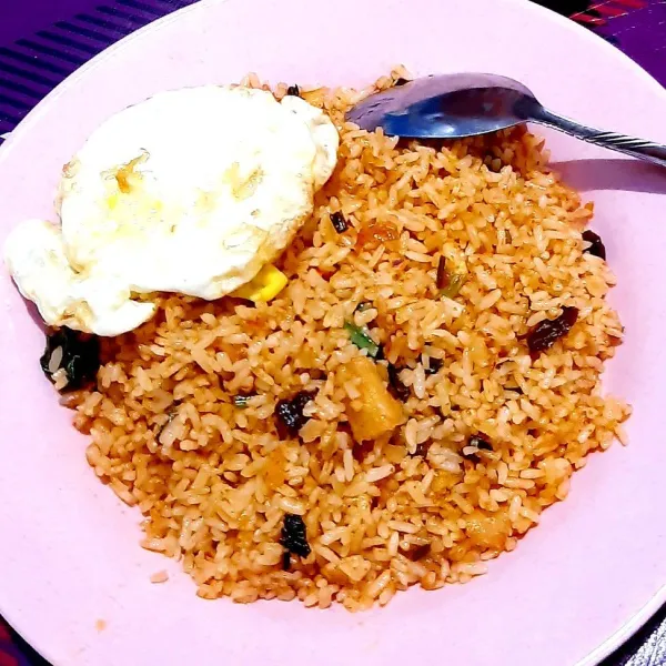 Setelah rasa nasi goreng sudah pas di lidah, nasi goreng siap dihidangkan. Tambahkan telur ceplok, timun, daun selada dan tomat untuk mempercantik hidangan