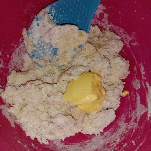 Terakhir masukkan margarine, aduk rata kemudian aduk sebentar menggunakan tangan hanyq untuk mencampur adonan dengan margarine, bulatkan lalu diamkan hingga adonan mengembang