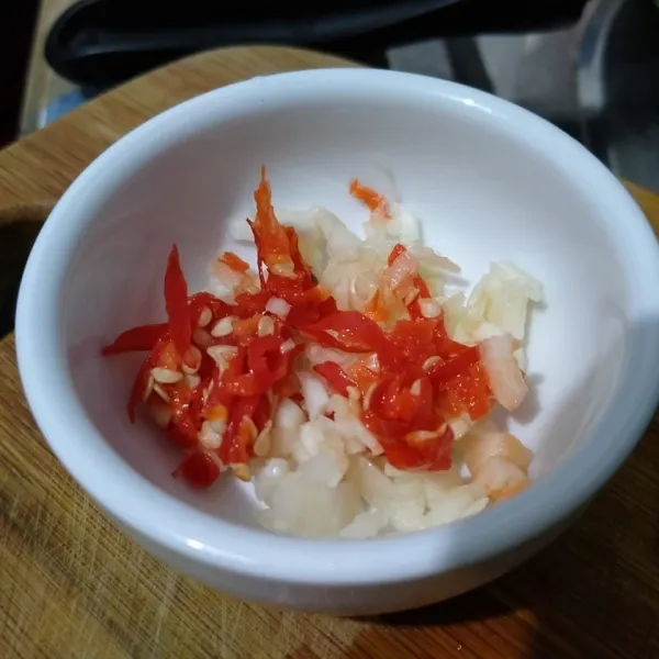 Cincang bawang putih dan iris cabe rawit. Masukkan dalam mangkuk