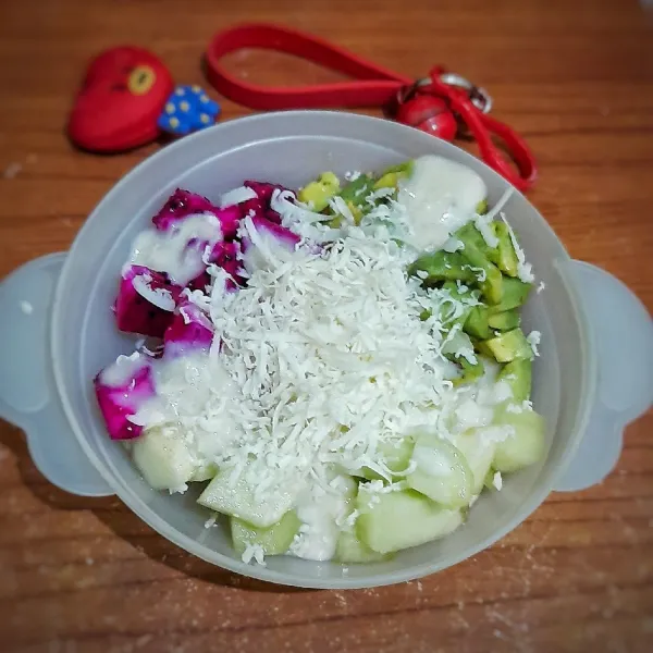 Tata buah-buahan di mangkok, lalu tuang saus pisang diatasnya. Terakhir, beri parutan keju di atasnya. Sajikan