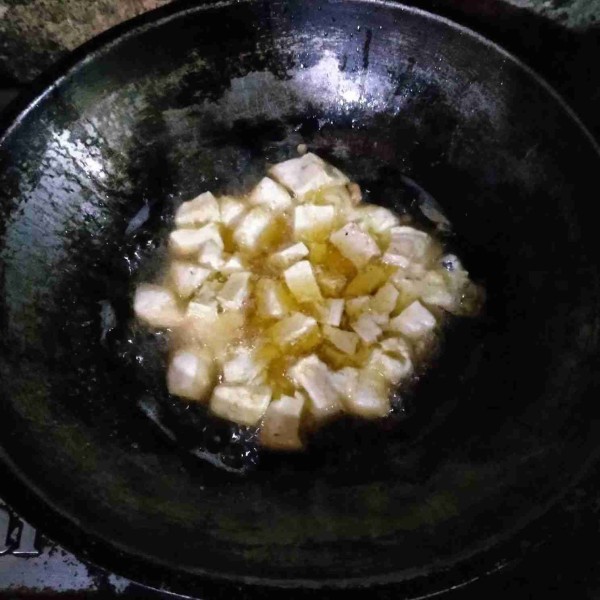 Goreng tahu dalam minyak yang sudah dipanaskan dengan api sedang sampai matang