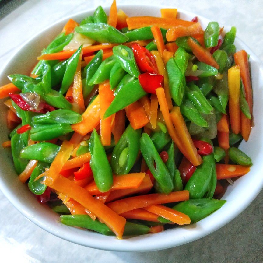 Bahan-bahan tumis buncis dan wortel dalam wadah kayu