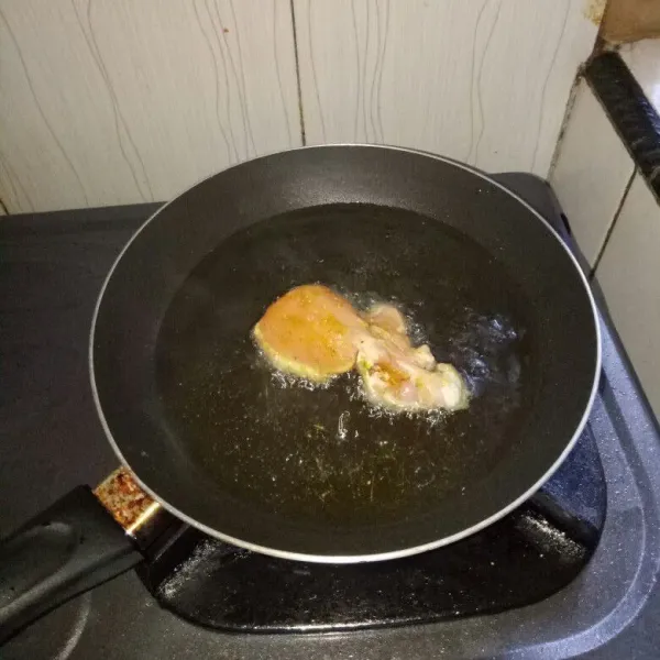 Siapkan pan, panaskan minyak. Goreng ayam dengan api kecil sampai matang. Tingkat kematangan sesuai selera atau hingga kuning keemasan