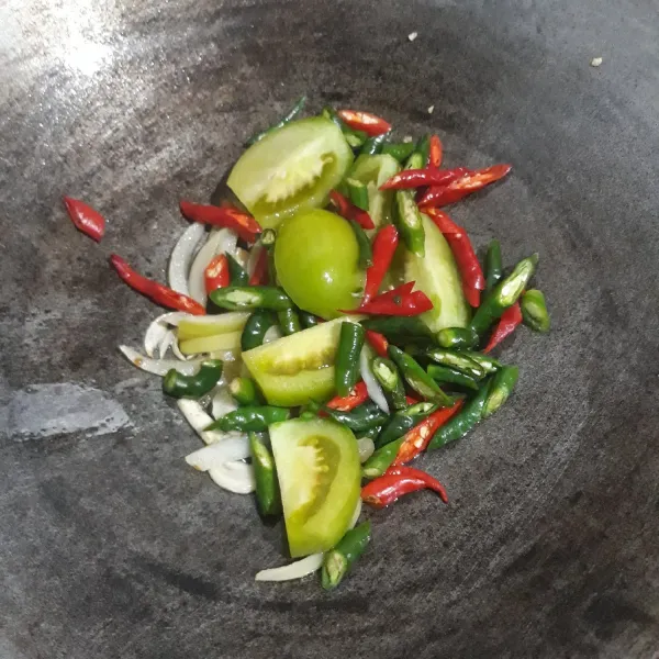 Lalu masukkan cabe merah keriting, cabe rawit merah, cabe hijau dan tomat hijau aduk-aduk sampai layu