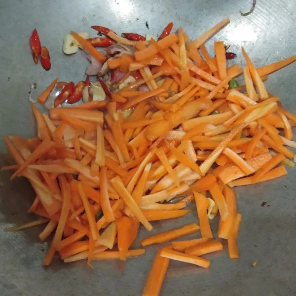Masukkan wortel, tumis sampai setengah matang.