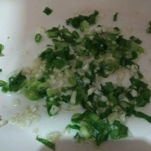 Tumis dengan api kecil, bawang putih hingga harus, masukkan daun bawang. Masak hingga wangi