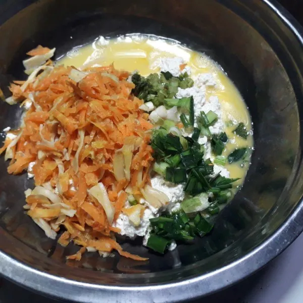 Masukkan ke dalam mangkuk berisi tahu halus, telur, daun bawang dan seledri iris