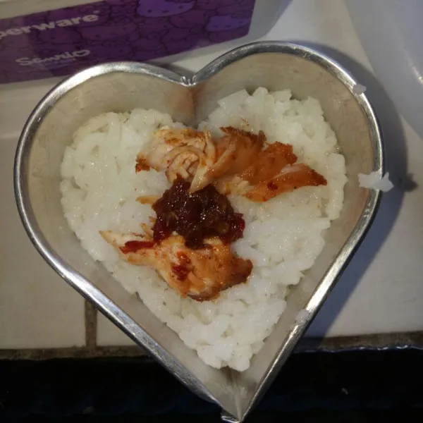 Siapkan cetakan onigiri dan olesi dengan minyak wijen, atau pakai cetakan kue kecil. Ambil 1 sdm nasi tata di dasar cetakan disusul masukam ayam penyet, lalu beri nasi lagi. Tekan tekan sampai terbentuk
