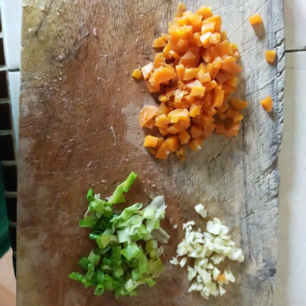 Iris tipis-tipis daun bawang dan 1 buah bawang putih. Potong kotak-kotak wortel dan ayam lalu sisihkan