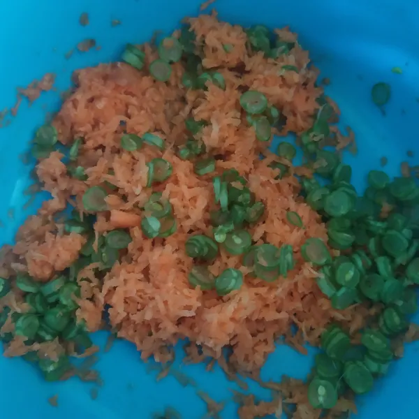 Kupas wortel, cuci bersih bersama buncis, parut wortel dengan parutan keju, iris tipis buncis