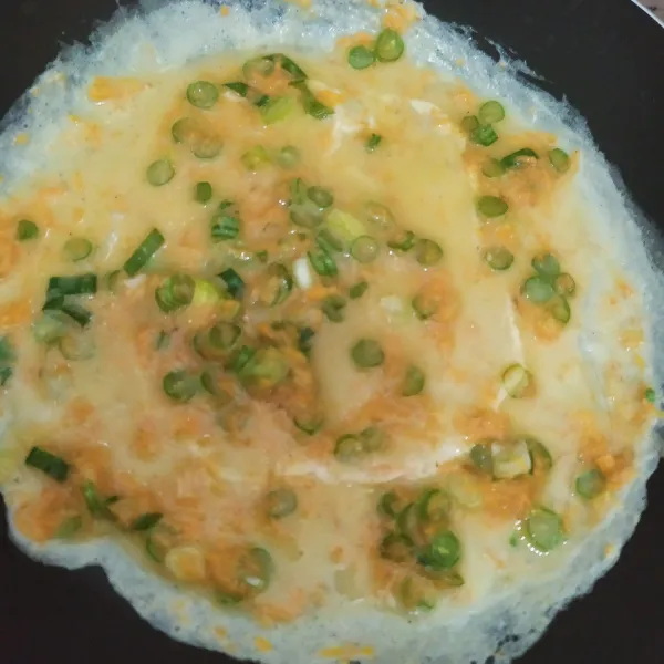 Panaskan teflon dengan 1 sdm minyak, tuang adonan sebanyak 1 sendok sayur, ratakan, masak sampai telur set