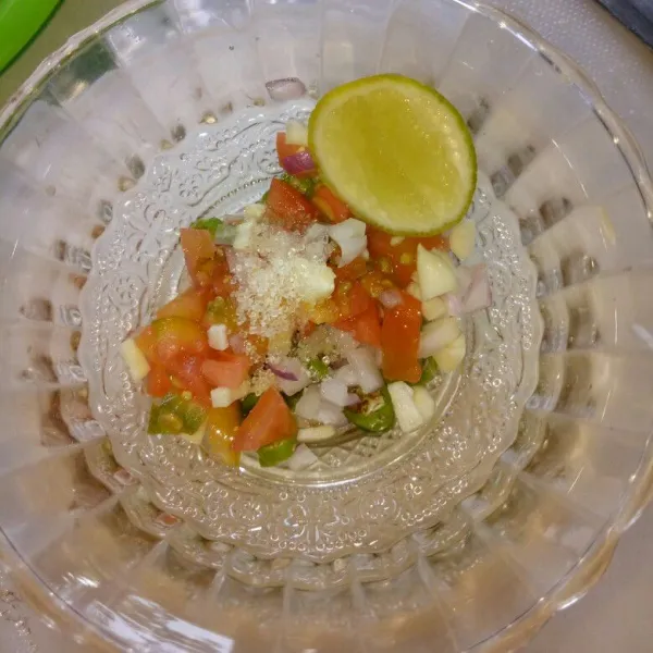 Siapkan mangkok kecil, masukkan bahan saos salsa yang sudah diiris tadi, aduk rata dengan gula pasir, kecap ikan dan perasan air jeruk nipis