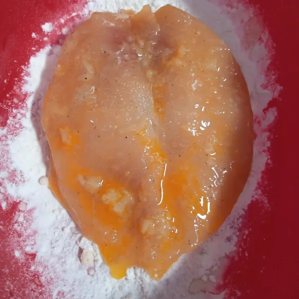 Celupkan dada ayam kedalam kocokan telur. Gulingkan pada tepung bumbu. Kemudian celupkan lagi ke dalam kocokan telur
