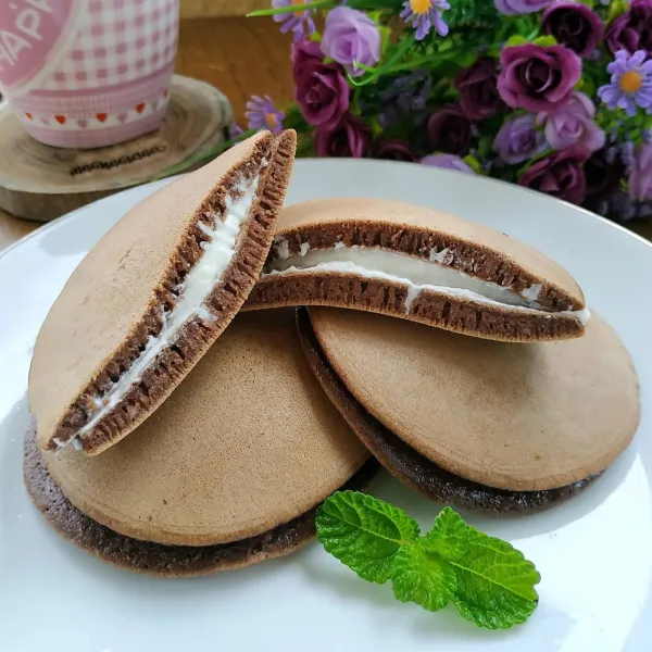 Ambil 1 buah kulit dorayaki, tambahkan buttercream ditengah kemudian tumpuk dengan kulit lain. Lakukan hingga semua selesai