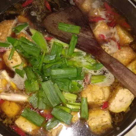 Setelah mendidih masukkan daun bawang, penyedap dan gula pasir. Aduk rata, koreksi rasa