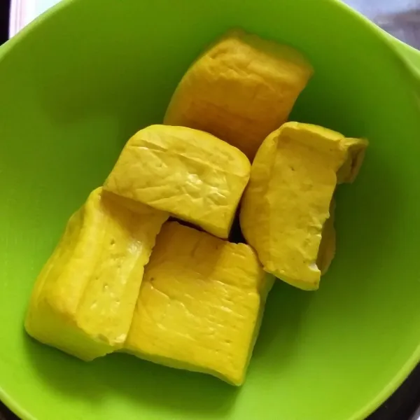 siapkan tahu sutra, siram dengan air panas kemudian haluskan.