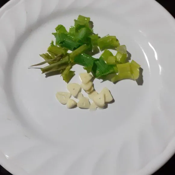 Potong bawang putih dan daun bawang.