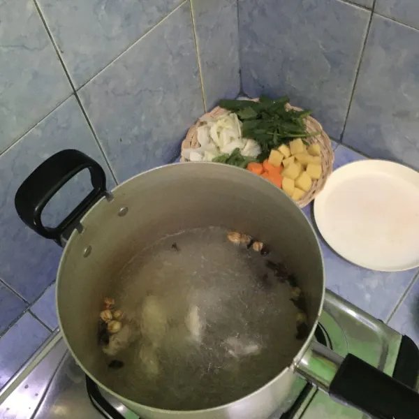Didihkan air lalu tambahkan ayam dan rempah. Tutup panci selama 3 menit